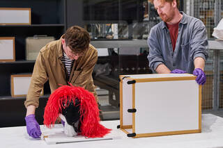 two people unpack a punk hat in a study centre