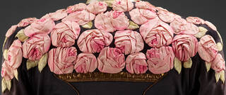 Crop of a pink jacket with three square buttons and multicoloured collar